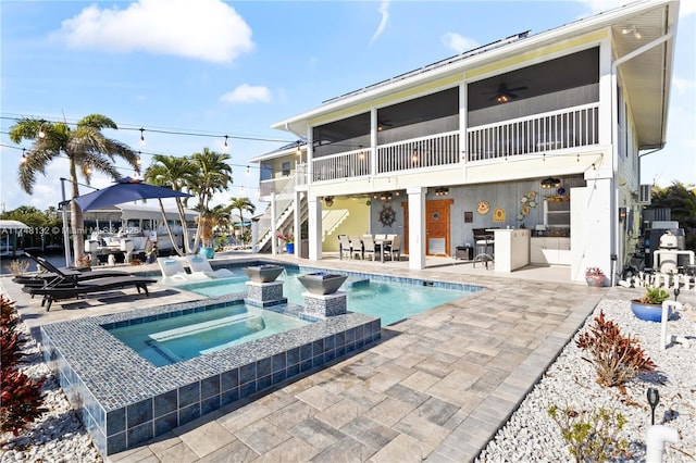 back of property featuring a patio area, a pool with connected hot tub, stairs, and a ceiling fan