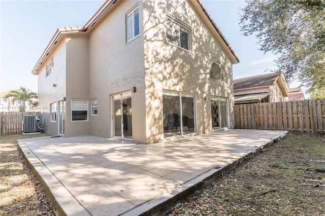rear view of house featuring a patio, fence, cooling unit, and stucco siding