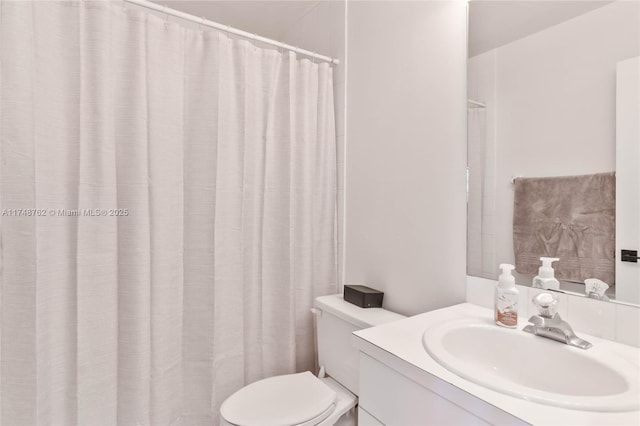 bathroom featuring toilet, vanity, and a shower with shower curtain