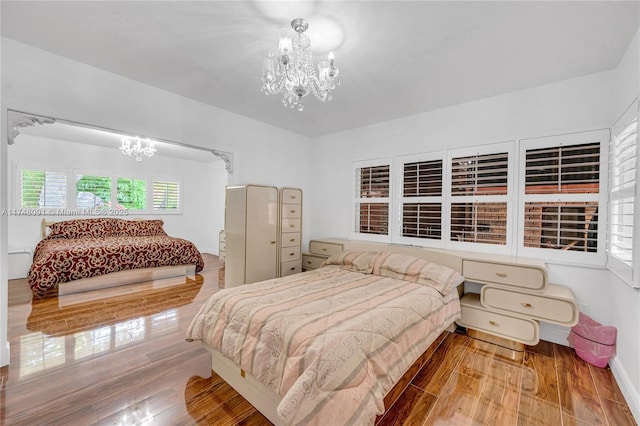 bedroom featuring a chandelier and wood finished floors