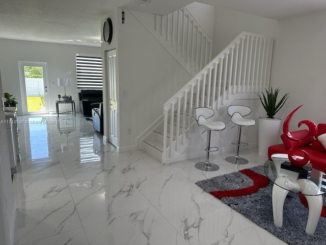 stairs with marble finish floor and baseboards