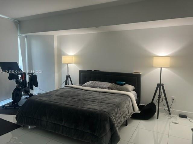 bedroom with light tile patterned floors and baseboards