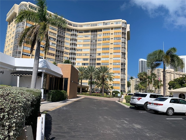 view of building exterior with uncovered parking and a city view