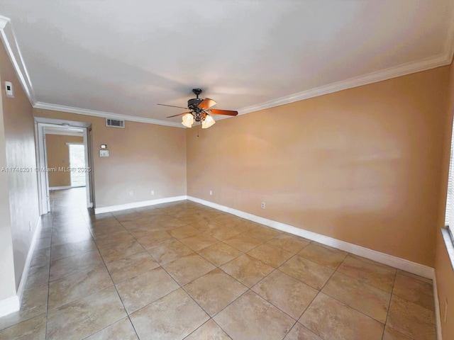 spare room with baseboards, visible vents, and crown molding