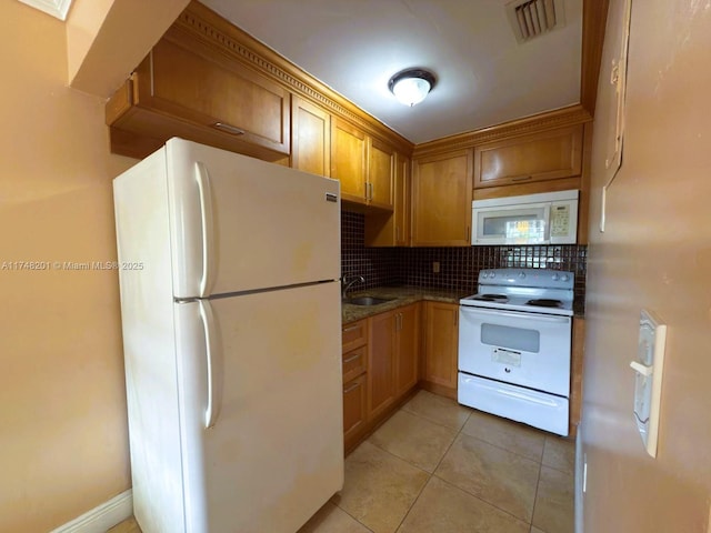 kitchen with light tile patterned flooring, white appliances, a sink, visible vents, and backsplash