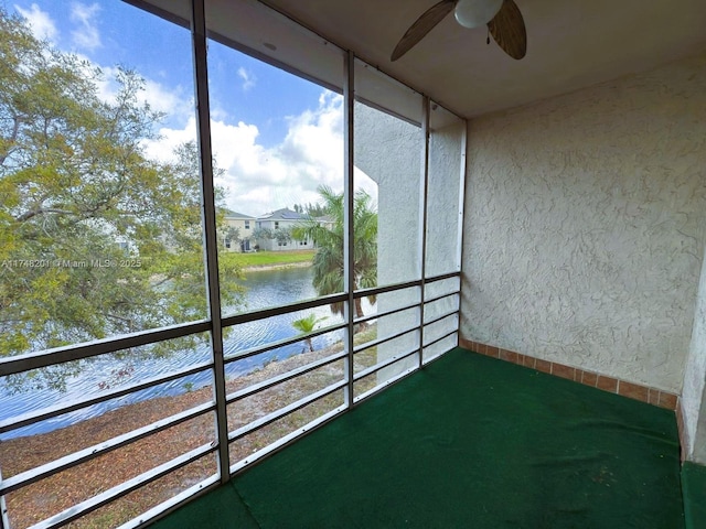 unfurnished sunroom with a water view and a ceiling fan