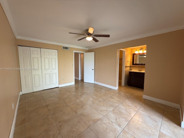 unfurnished bedroom with ornamental molding, a closet, visible vents, and baseboards