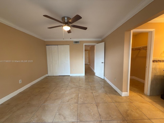 unfurnished bedroom featuring ornamental molding, a closet, visible vents, and baseboards