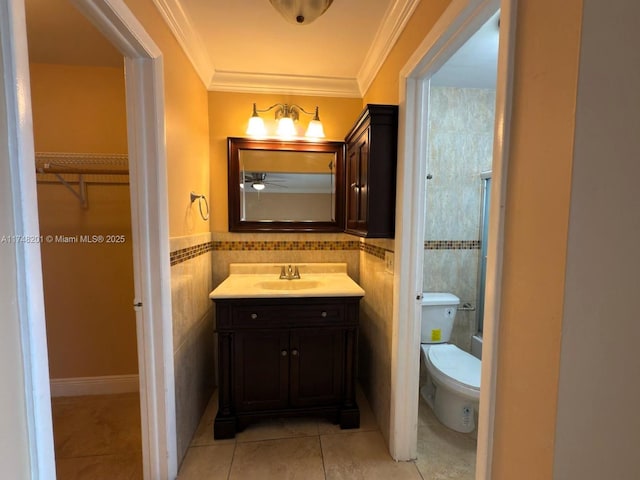 bathroom with vanity, tile walls, a spacious closet, tile patterned floors, and crown molding