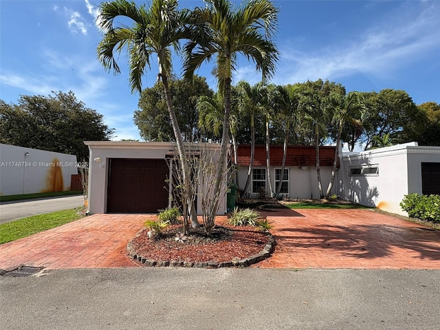 view of front of property with a garage, decorative driveway, and stucco siding