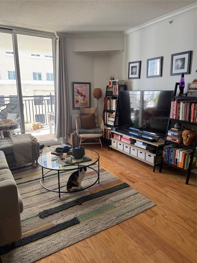 living area featuring crown molding, floor to ceiling windows, wood finished floors, and a textured ceiling