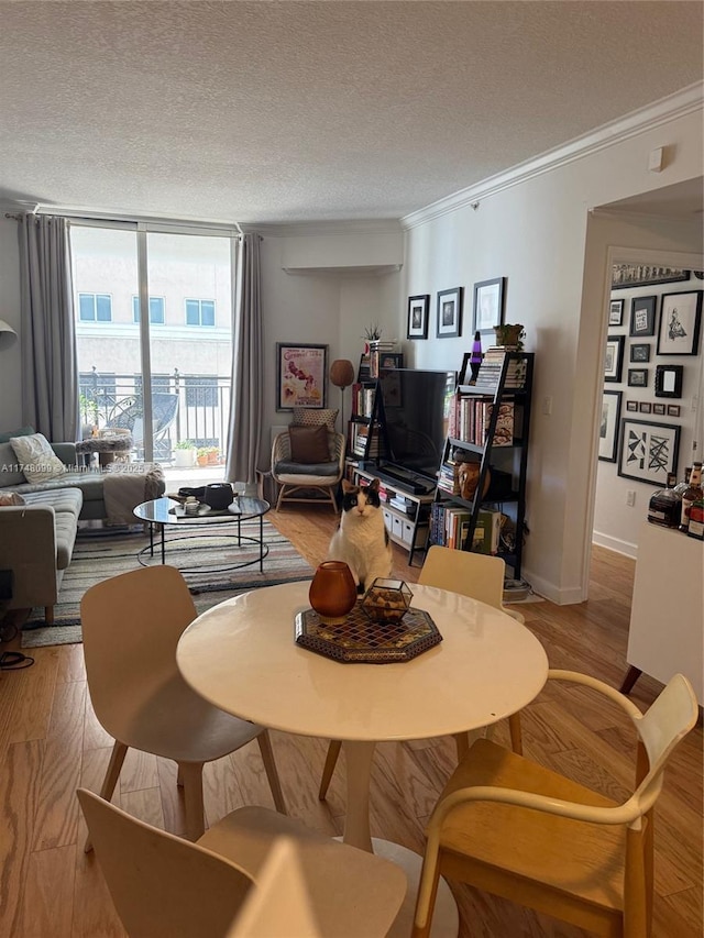 living room with a textured ceiling, expansive windows, wood finished floors, and ornamental molding