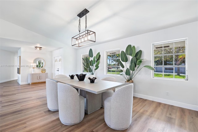 dining space with plenty of natural light, baseboards, and light wood finished floors