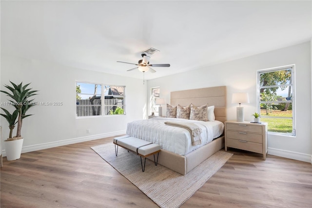 bedroom with ceiling fan, visible vents, baseboards, and light wood-type flooring