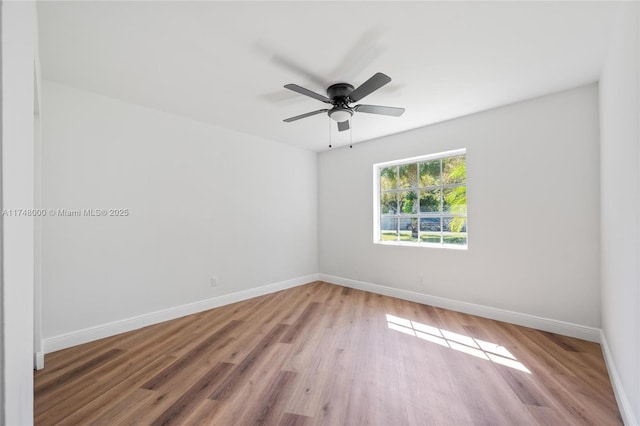 spare room with baseboards, a ceiling fan, and light wood-style flooring