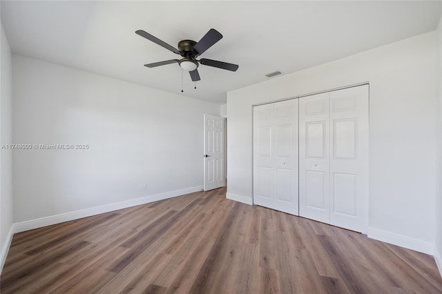 unfurnished bedroom with baseboards, visible vents, and wood finished floors