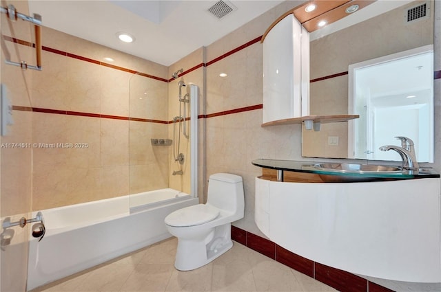 bathroom featuring tile walls, shower / bathtub combination, visible vents, toilet, and vanity