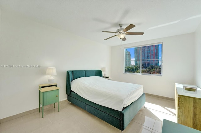 bedroom featuring light tile patterned floors, baseboards, and a ceiling fan