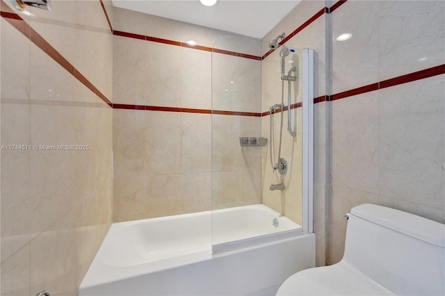 full bathroom featuring toilet, tile walls, and shower / bathtub combination