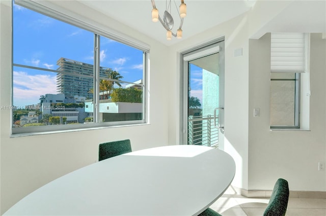 dining room with a view of city, a notable chandelier, and light tile patterned flooring