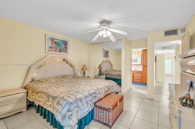 bedroom with a ceiling fan, light tile patterned flooring, visible vents, and a closet