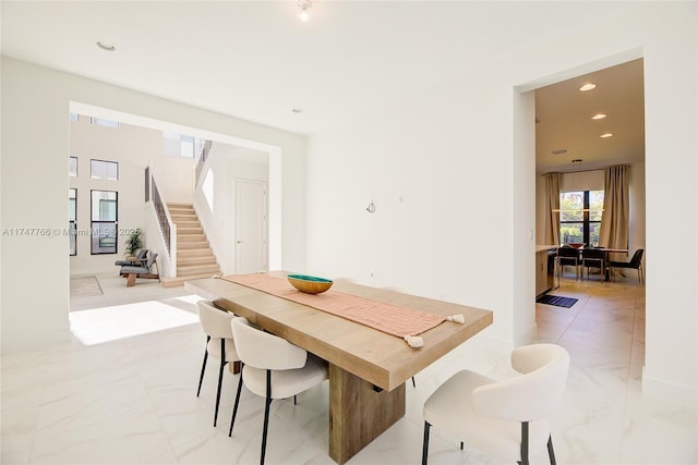 dining area with recessed lighting, marble finish floor, and stairs