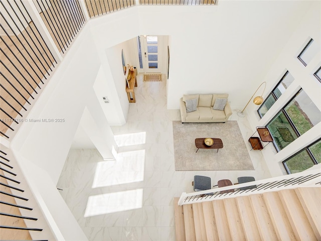 living room with plenty of natural light, a high ceiling, and stairs