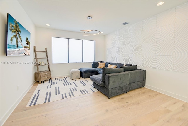 living room with visible vents, baseboards, wood finished floors, and recessed lighting