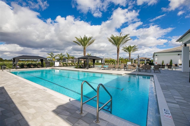 community pool featuring fence, a patio, and a gazebo