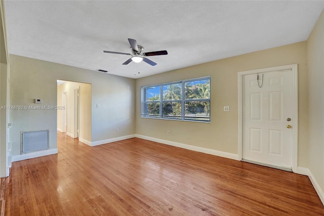 unfurnished living room with light wood finished floors, visible vents, and baseboards