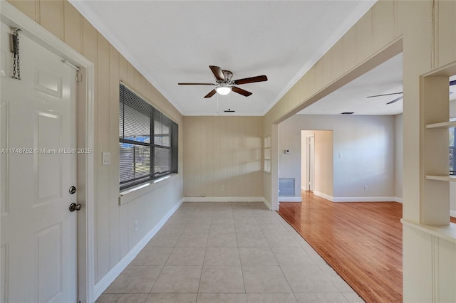 spare room featuring ceiling fan, ornamental molding, light wood finished floors, and baseboards