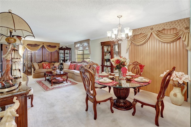 dining space featuring light carpet, crown molding, a textured ceiling, and an inviting chandelier