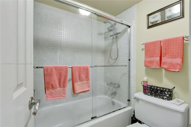 bathroom with toilet and combined bath / shower with glass door