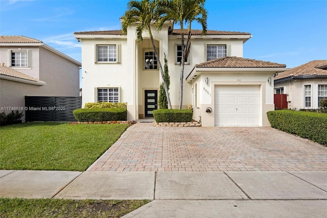 view of front of home with stucco siding, a garage, a tiled roof, decorative driveway, and a front yard