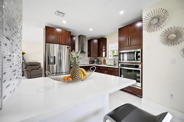 8851 SW 208th Ter, Cutler Bay, FL 33189 - kitchen featuring visible vents, light countertops, backsplash, stainless steel appliances, and wall chimney range hood
