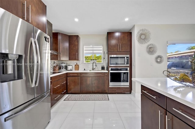8851 SW 208th Ter, Cutler Bay, FL 33189 - kitchen featuring light tile patterned floors, light countertops, stainless steel appliances, a sink, and decorative backsplash