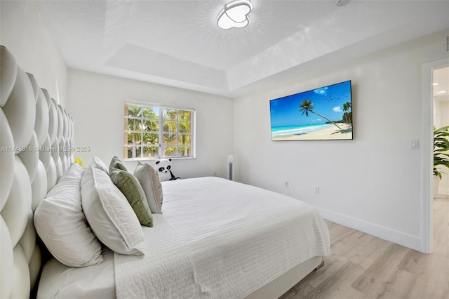 8851 SW 208th Ter, Cutler Bay, FL 33189 - bedroom with baseboards, light wood finished floors, a tray ceiling, and a textured ceiling