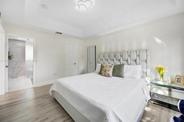 8851 SW 208th Ter, Cutler Bay, FL 33189 - bedroom featuring visible vents, baseboards, a raised ceiling, and light wood-type flooring