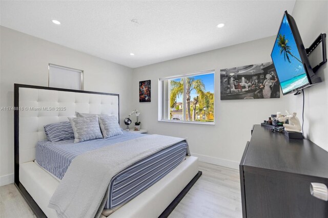 8851 SW 208th Ter, Cutler Bay, FL 33189 - bedroom with baseboards, light wood-style floors, recessed lighting, and a textured ceiling