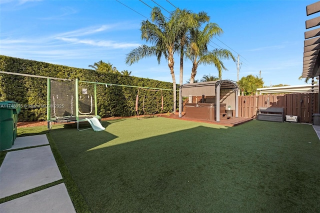 8851 SW 208th Ter, Cutler Bay, FL 33189 - view of yard with a hot tub, a trampoline, and a fenced backyard