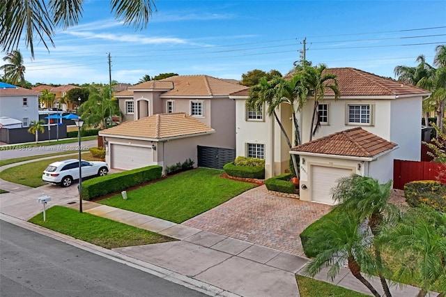 8851 SW 208th Ter, Cutler Bay, FL 33189 - mediterranean / spanish house featuring a front lawn, stucco siding, an attached garage, decorative driveway, and a tile roof
