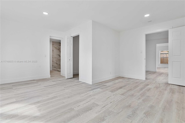 empty room featuring recessed lighting, light wood-style flooring, and baseboards