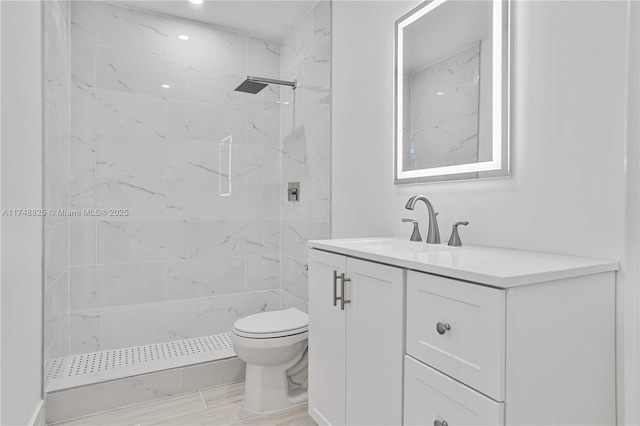 full bath featuring a stall shower, vanity, and toilet