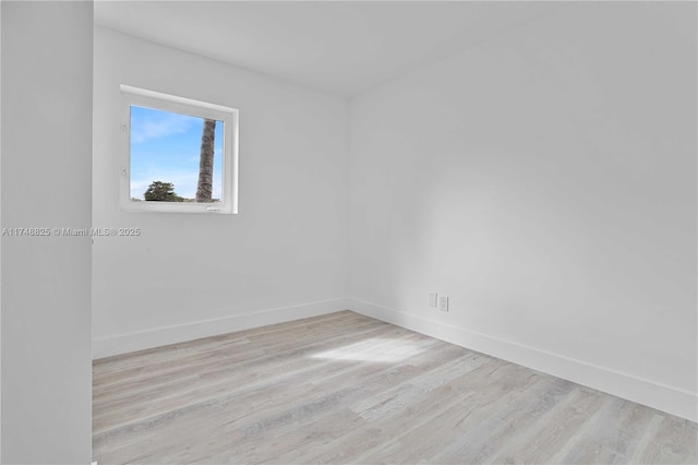 empty room featuring light wood finished floors and baseboards