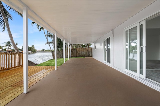 view of patio featuring a water view and fence