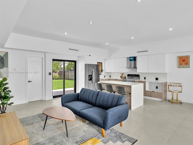 living area with recessed lighting, baseboards, and concrete flooring