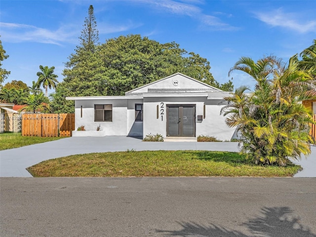 view of front of house with stucco siding, concrete driveway, and fence