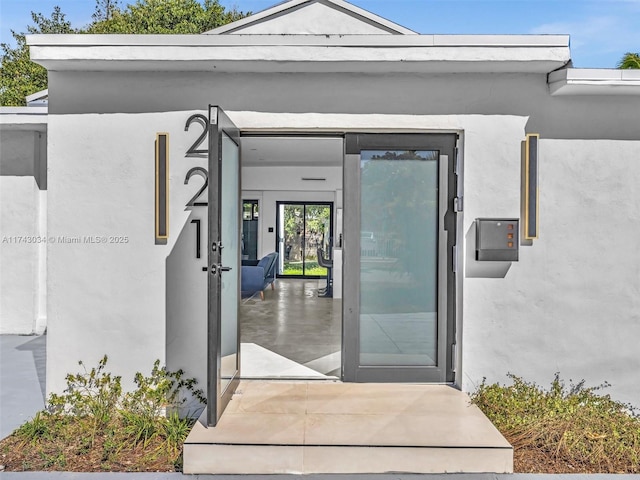 view of exterior entry with stucco siding