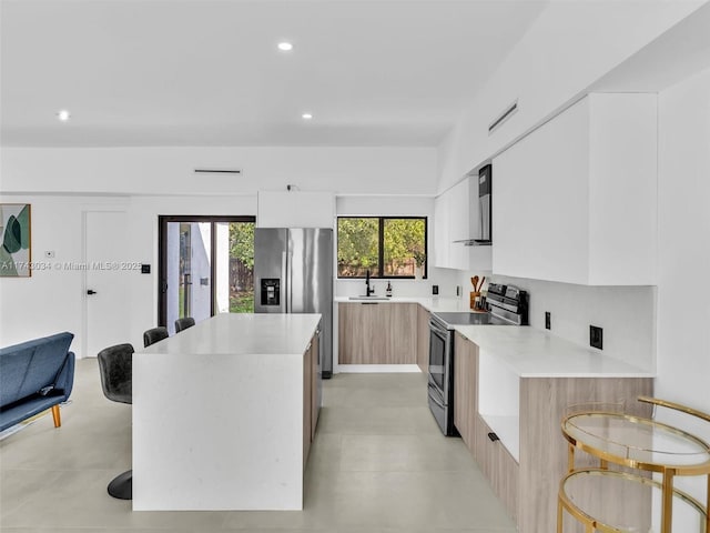 kitchen featuring light countertops, modern cabinets, a kitchen island, and stainless steel appliances