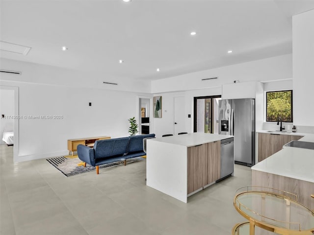 kitchen featuring recessed lighting, stainless steel appliances, light countertops, modern cabinets, and a center island